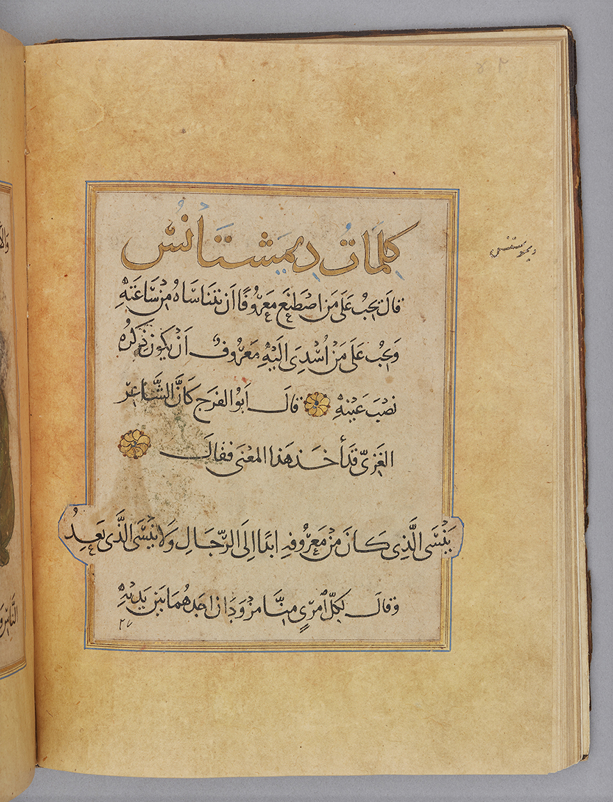 Manuscript page with left justified text box ruled with blue and gold, containing 8 lines of script in black with gold floral roundels as text-markers. The 1st line of script is larger and written in gold, and the 2nd last line of script extends past the text box margins.