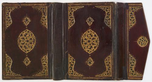 Burgundy leather bookbinding, laid flat with flap. Both sides of bookbinding are mirror images. Decorated with a gold gilt-stamped medallion in the centre, and similar corner pieces. 