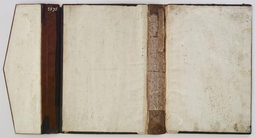 Interior of bookbinding, laid open flat, front and back panels are blank, with visible wear on the spine where it would have been attached to the pages.