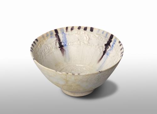 White bowl of deep rounded form, manganese purple and cobalt-blue lines with manganese dashes between them around the rim. 