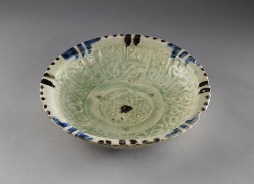 Bowl with everted rim, decorated with manganese purple and cobalt blue splashes in a transparent glaze with a slightly greenish cast, with a central medallion filled with a bold calligraphic band of flowing cursive script interspersed with leaves and scrolls.