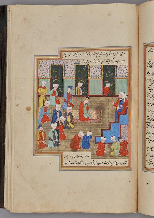 Painting within a rectangular border of blue, gold, green, and red, lines of script at the top and bottom. Prince sits on a carpet and figures kneel in front of a figure sitting on steps.    