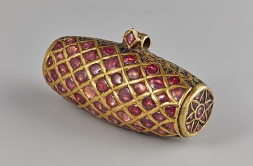 Cylindrically-shaped pendant, view of side that is encrusted with rubies on one side and slight view of the decorated in green enamel on the back.