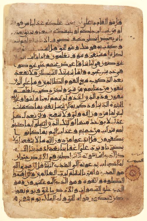 Folio with twenty-two lines of Kufic script in dark brown ink on buff paper, with gold accents and vocalisation in red, yellow and green. 