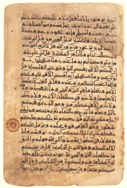 Folio with twenty-two lines of Kufic script in dark brown ink on buff paper, with gold accents and vocalisation in red, yellow and green. 